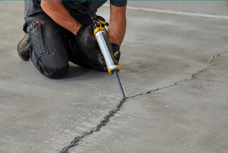 Comblement d'une fissure du sol béton au mastic polyuréthane souple