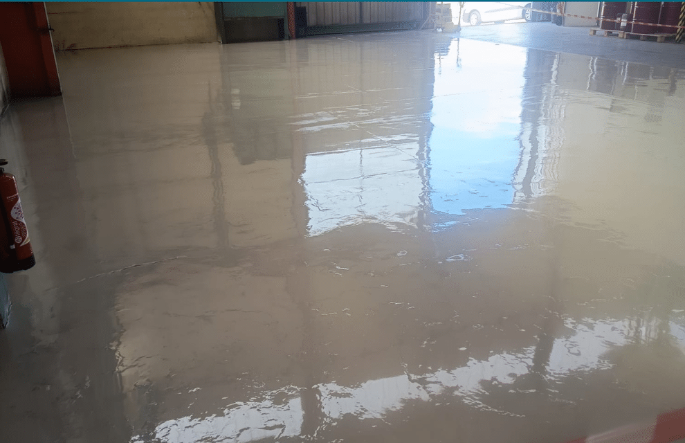 Sol industriel fini en résine polyuréthane grise, surface plane et brillante